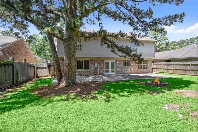 12522 Bent Pine Dr, Cypress, TX 77429 - back of house with a lawn, brick siding, french doors, a patio area, and a fire pit