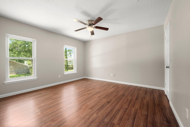 12522 Bent Pine Dr, Cypress, TX 77429 - empty room featuring baseboards, a wealth of natural light, dark wood finished floors, and ceiling fan