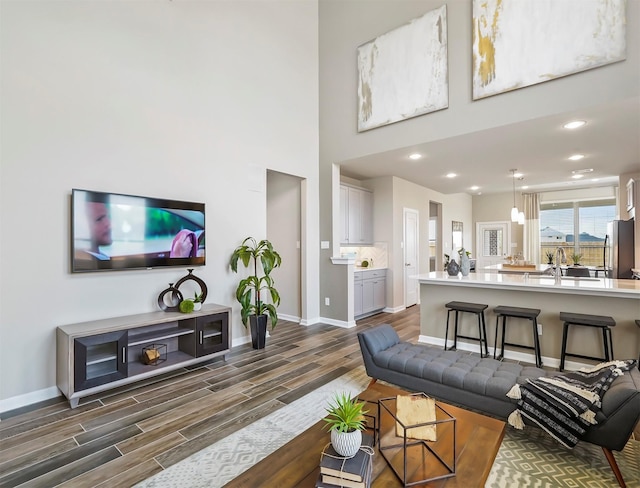 living room featuring baseboards, dark wood-style floors, and recessed lighting