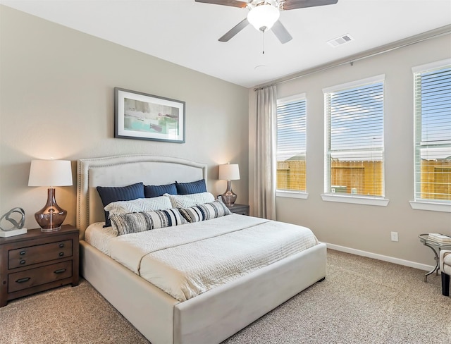 bedroom featuring multiple windows, visible vents, baseboards, and light carpet