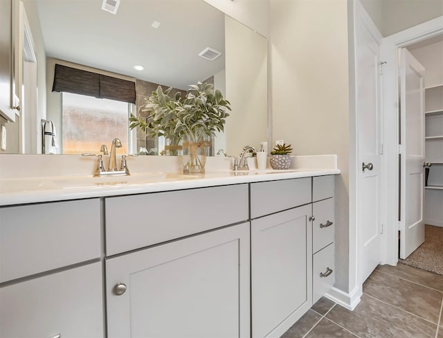 full bath with tile patterned floors, double vanity, visible vents, and a sink