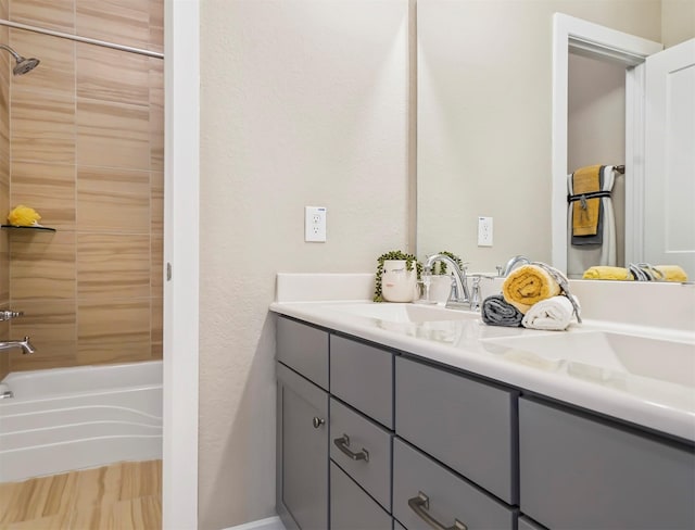 full bath featuring double vanity, washtub / shower combination, and a sink