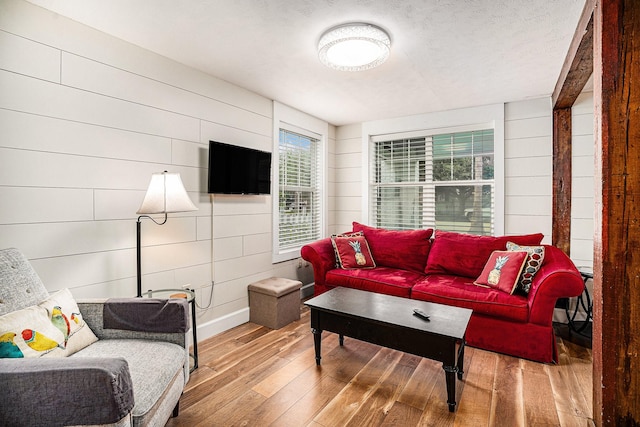 living area with wood walls and hardwood / wood-style floors