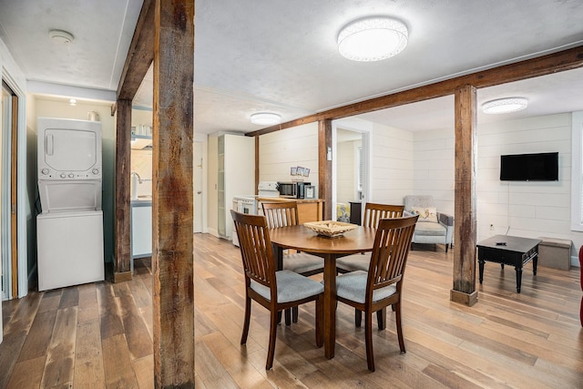 dining area featuring light wood-type flooring and stacked washer / drying machine