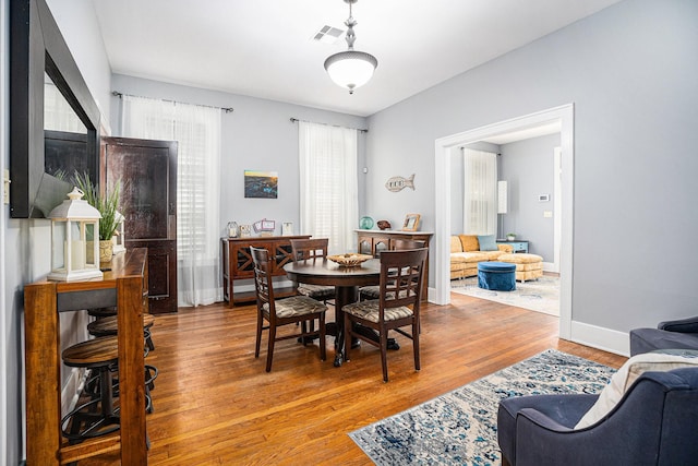 dining space featuring baseboards, visible vents, and wood finished floors