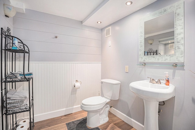 half bath featuring recessed lighting, toilet, baseboards, visible vents, and wood finished floors