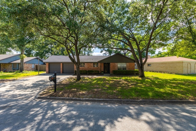 2002 Willowbend St, Conroe, TX 77301 - view of front facade featuring an attached garage, driveway, a front lawn, and brick siding
