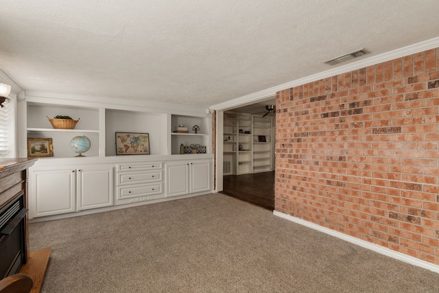 2002 Willowbend St, Conroe, TX 77301 - interior space with carpet, a textured ceiling, brick wall, ornamental molding, and a fireplace