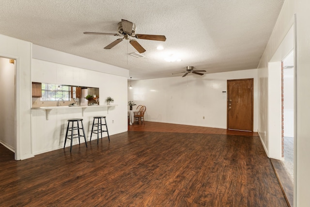 2002 Willowbend St, Conroe, TX 77301 - unfurnished living room featuring ceiling fan, a textured ceiling, dark wood-style floors, and a sink
