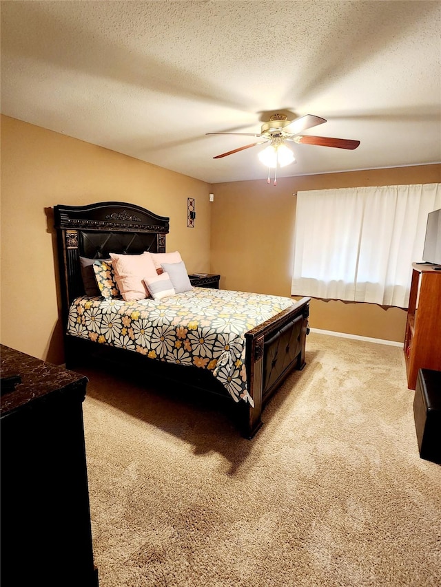 carpeted bedroom featuring a textured ceiling and a ceiling fan