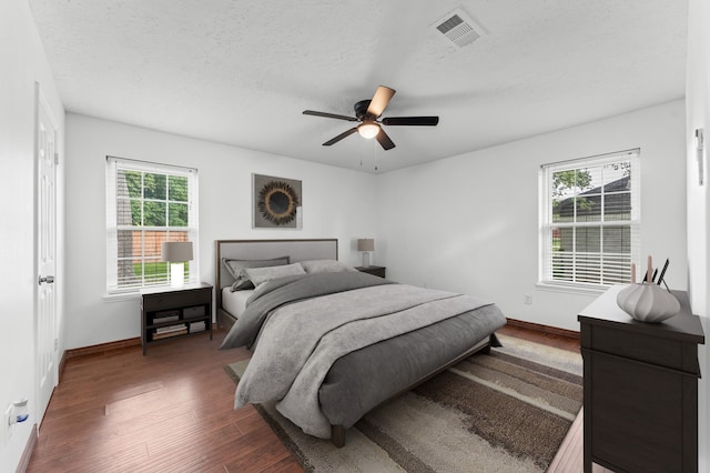 1711 Park Dr, La Porte, TX 77571 - bedroom featuring dark wood-style floors, baseboards, a ceiling fan, and a textured ceiling