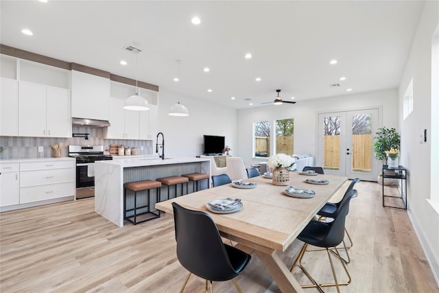 dining space with light wood finished floors, french doors, visible vents, and recessed lighting