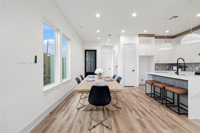 dining room featuring recessed lighting, baseboards, visible vents, and light wood-style floors
