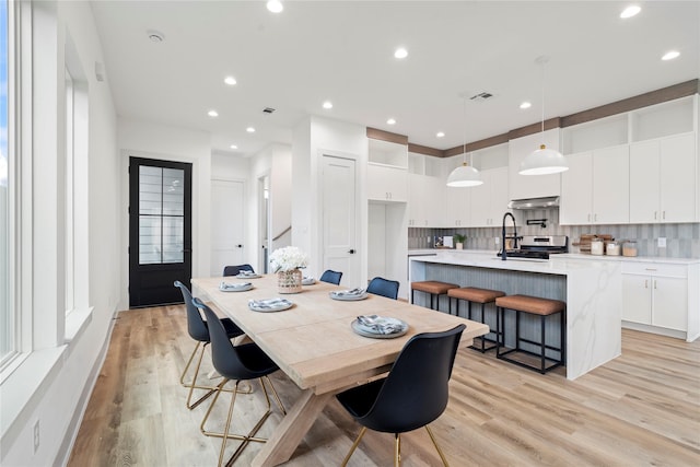 dining space featuring light wood finished floors, recessed lighting, and visible vents