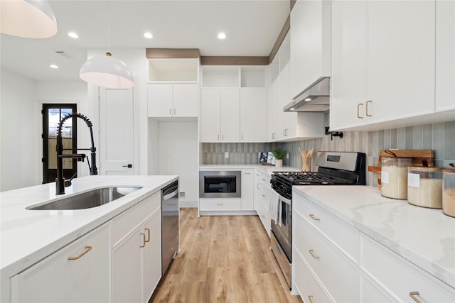 kitchen featuring a sink, stainless steel appliances, white cabinetry, light wood-type flooring, and under cabinet range hood