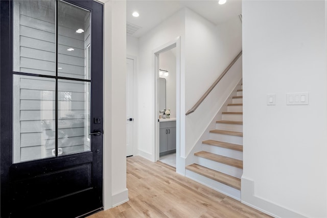 foyer featuring stairs, wood finished floors, visible vents, recessed lighting, and baseboards