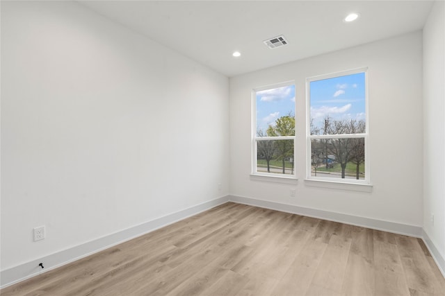 spare room featuring baseboards, recessed lighting, light wood finished floors, and visible vents
