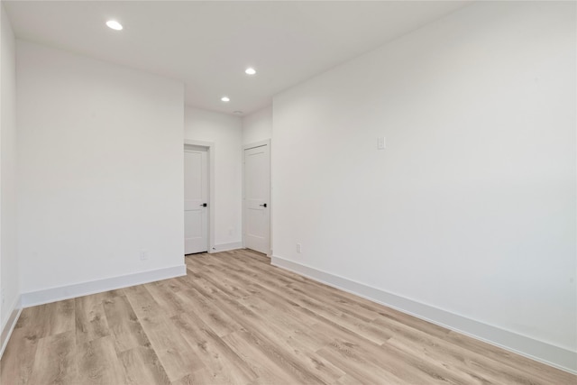 empty room featuring light wood-style floors, baseboards, and recessed lighting