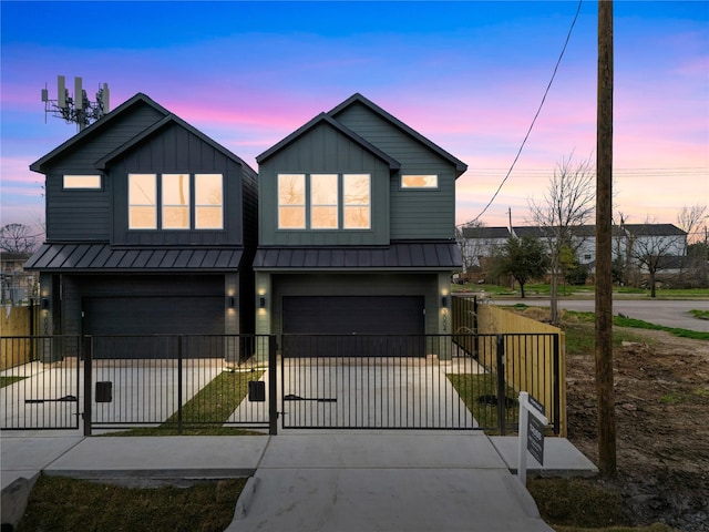 modern inspired farmhouse with a gate, fence, an attached garage, and driveway