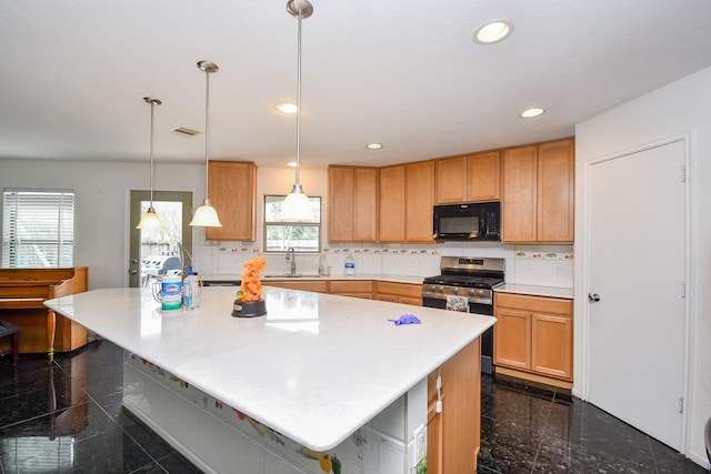 kitchen featuring stainless steel range with gas stovetop, visible vents, black microwave, light countertops, and granite finish floor