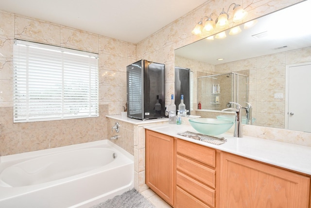 bathroom featuring a stall shower, vanity, a bath, and visible vents