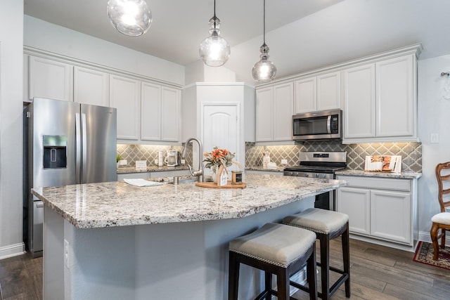 29411 Barker Meadow Ln, Katy, TX 77494 - kitchen with appliances with stainless steel finishes, a sink, an island with sink, dark wood-style floors, and backsplash