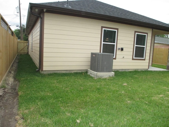 721 E Fayle St, Baytown, TX 77520 - rear view of house with cooling unit, a yard, roof with shingles, and a fenced backyard
