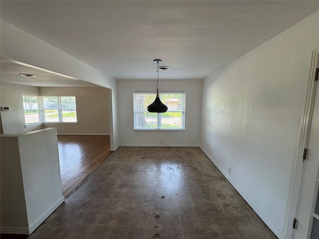 unfurnished dining area with baseboards