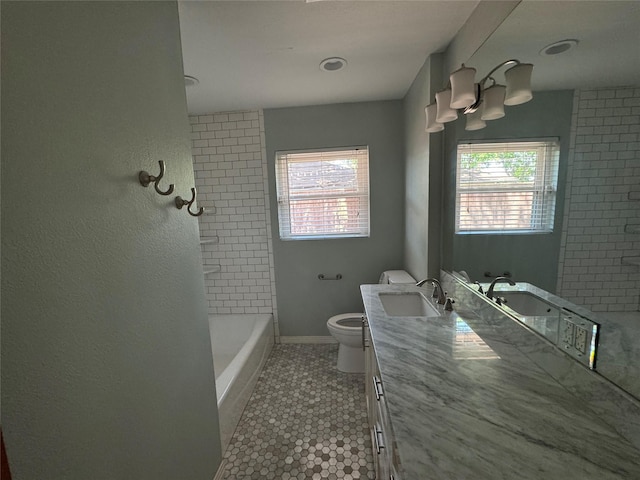 full bathroom featuring toilet, plenty of natural light, vanity, and tile patterned flooring