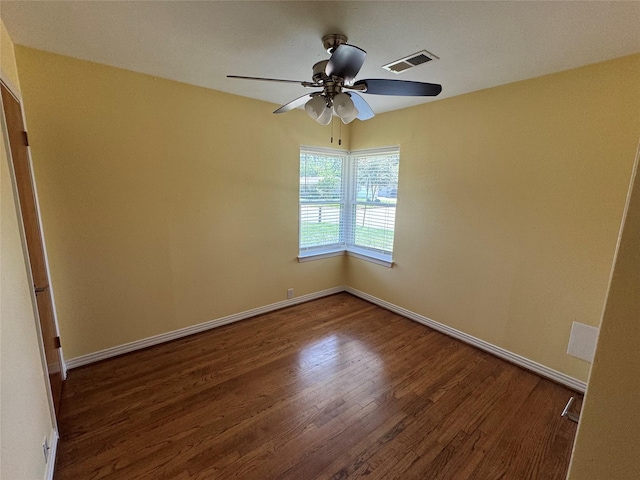 empty room featuring wood finished floors, a ceiling fan, and baseboards