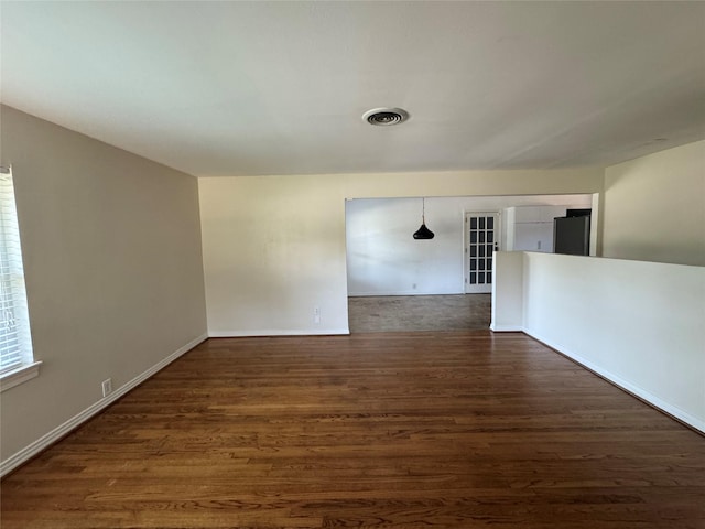 spare room with dark wood finished floors and baseboards