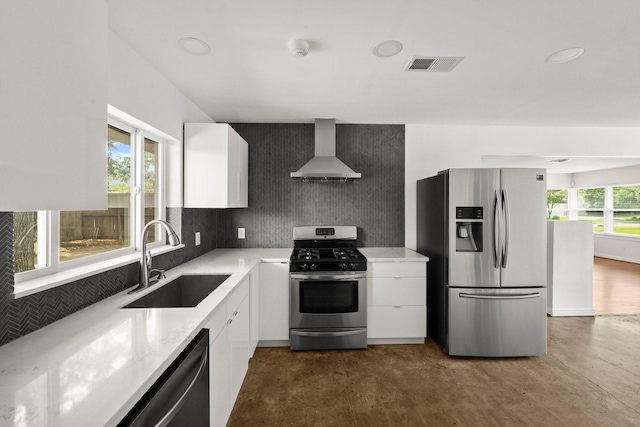 2218 Stonecrest, Houston, TX 77018 - kitchen featuring appliances with stainless steel finishes, wall chimney exhaust hood, a sink, white cabinetry, and concrete flooring