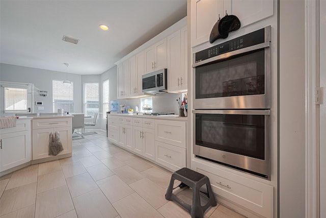 kitchen with white cabinets, light countertops, appliances with stainless steel finishes, and recessed lighting