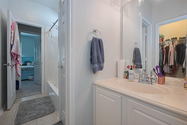 full bathroom with tile patterned flooring, a spacious closet, shower / bath combo, and vanity