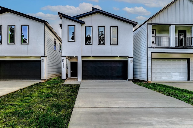 view of front of home featuring an attached garage, concrete driveway, stucco siding, and a balcony