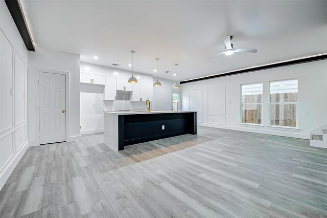 unfurnished living room featuring light wood-type flooring, a ceiling fan, baseboards, recessed lighting, and a sink