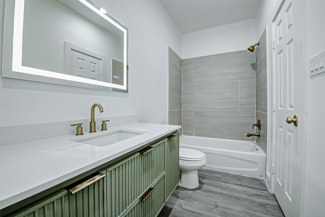 bathroom with wood finished floors, toilet, vanity, and shower / bath combination