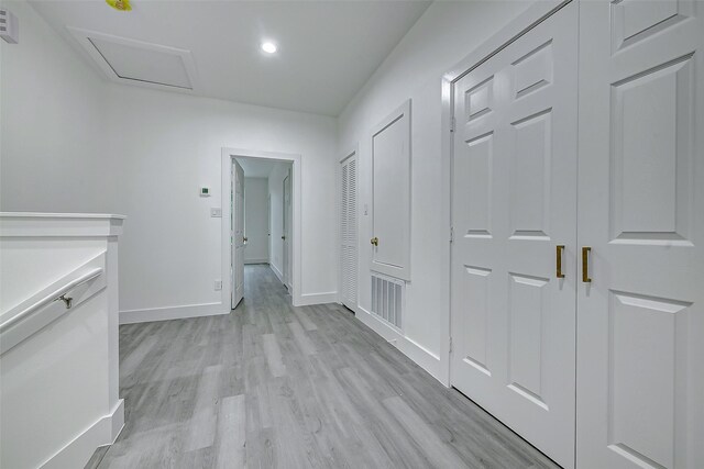 hallway with baseboards, light wood-style flooring, attic access, and recessed lighting