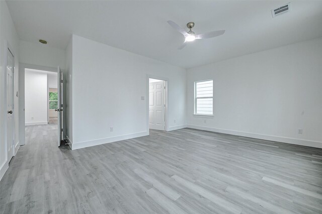 unfurnished room with ceiling fan, wood finished floors, plenty of natural light, and baseboards