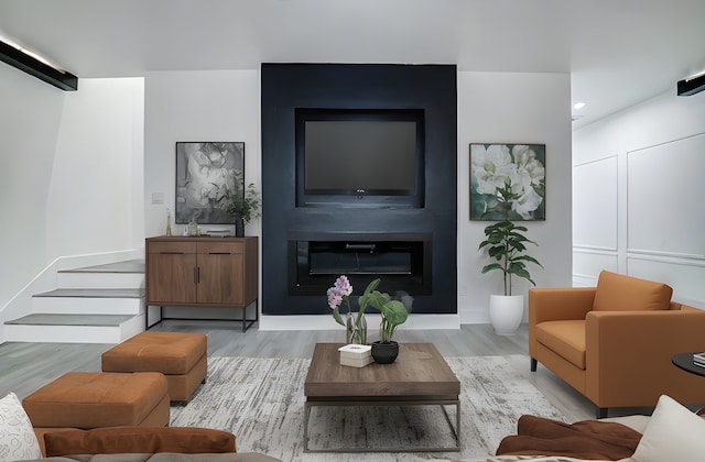 living room featuring wood finished floors, recessed lighting, and a glass covered fireplace