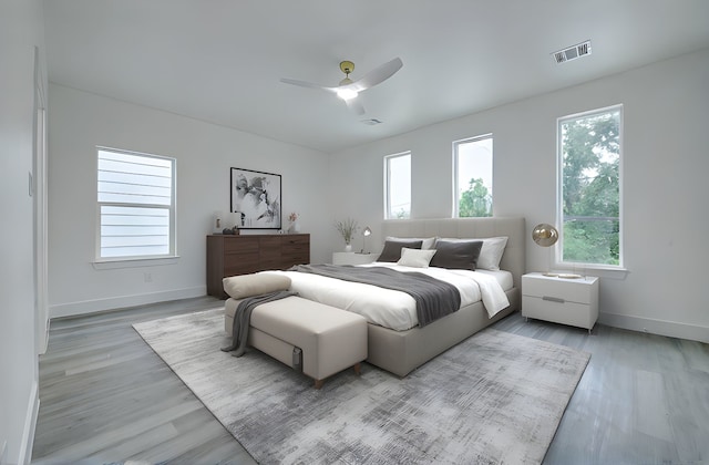 bedroom with multiple windows, wood finished floors, baseboards, and ceiling fan