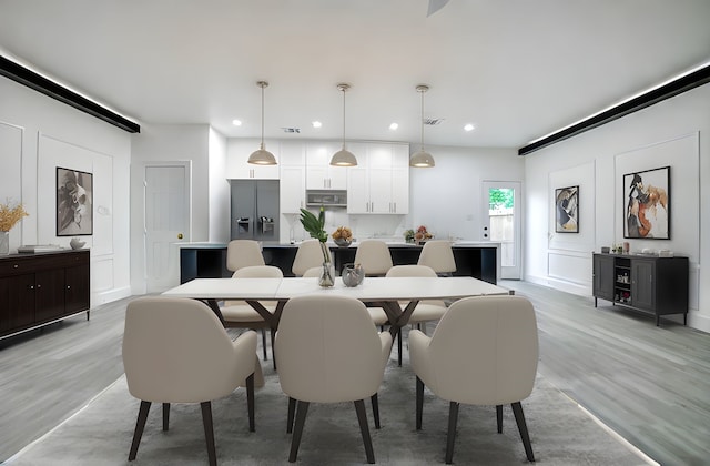 dining area featuring light wood finished floors and recessed lighting