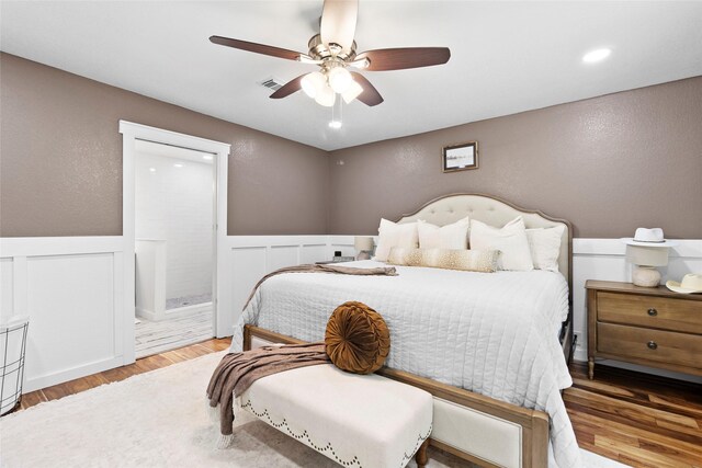 452 N Ghost Branch Rd, Trinity, TX 75862 - bedroom featuring wainscoting, visible vents, a decorative wall, wood finished floors, and a textured wall