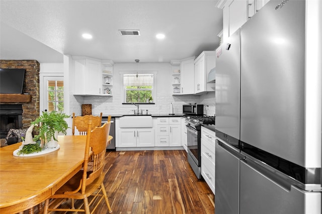 452 N Ghost Branch Rd, Trinity, TX 75862 - kitchen featuring a sink, open shelves, dark countertops, stainless steel appliances, and visible vents
