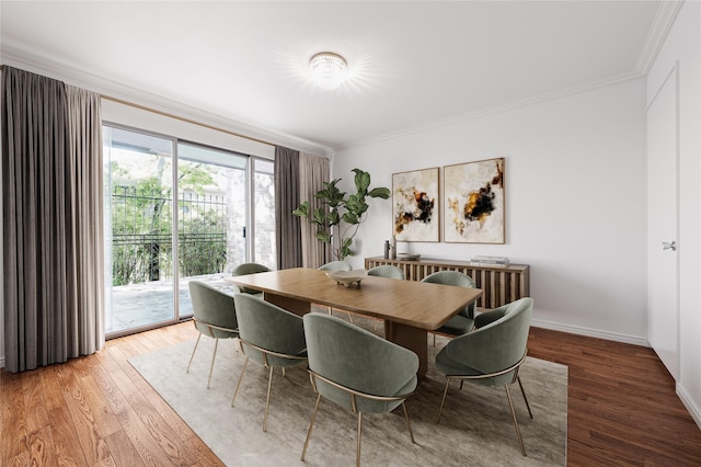 dining room featuring crown molding, light wood-type flooring, and baseboards
