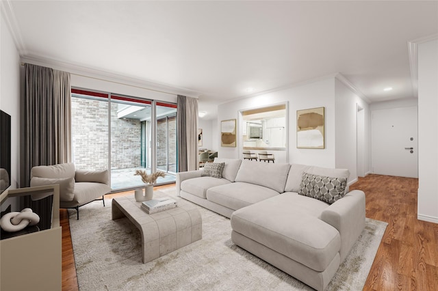 living room featuring ornamental molding, recessed lighting, and wood finished floors