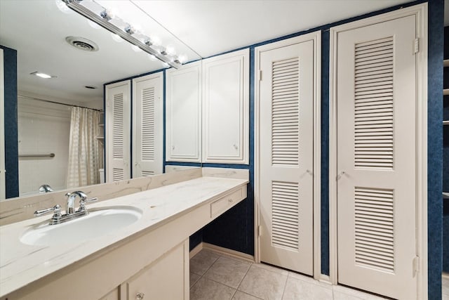 full bath featuring vanity, a closet, visible vents, and tile patterned floors