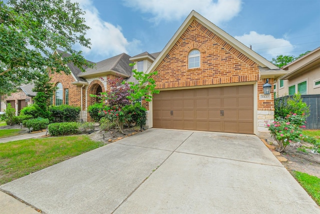 traditional-style home featuring a shingled roof, brick siding, driveway, and stone siding