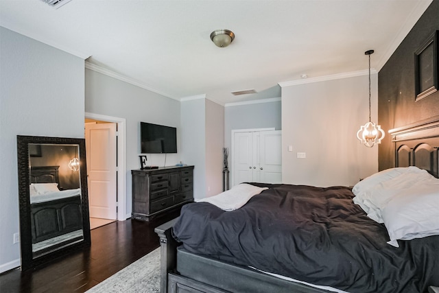 bedroom featuring crown molding, a closet, a chandelier, and wood finished floors