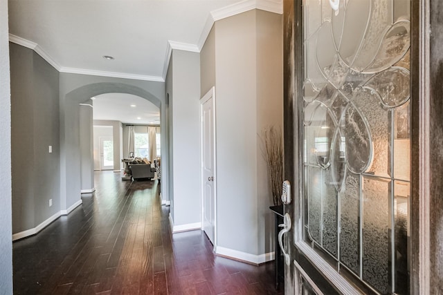 entrance foyer featuring ornamental molding, wood finished floors, baseboards, and arched walkways